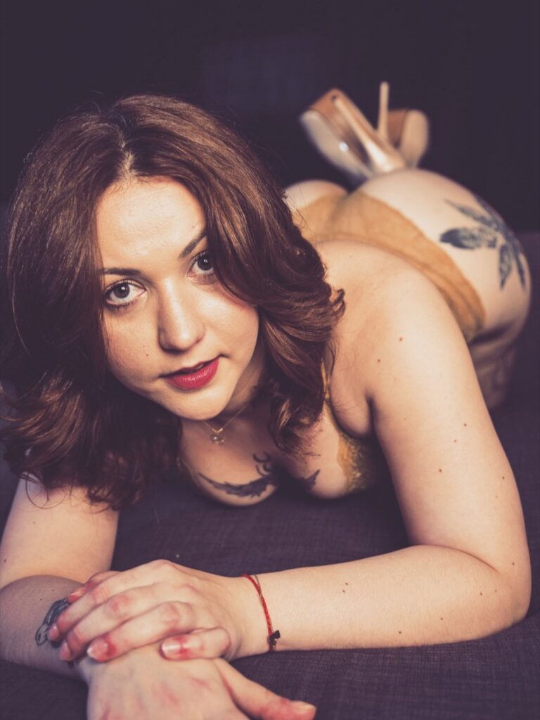 Célia French posant sensuellement sur le ventre, face à la caméra