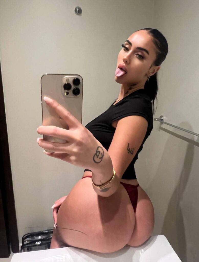 Linamycrush vue de dos, assise sur un lavabo, montrant ses fesses