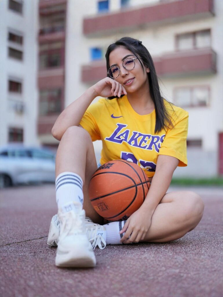 Itsxlilix posant sur le sol avec une balle de basket