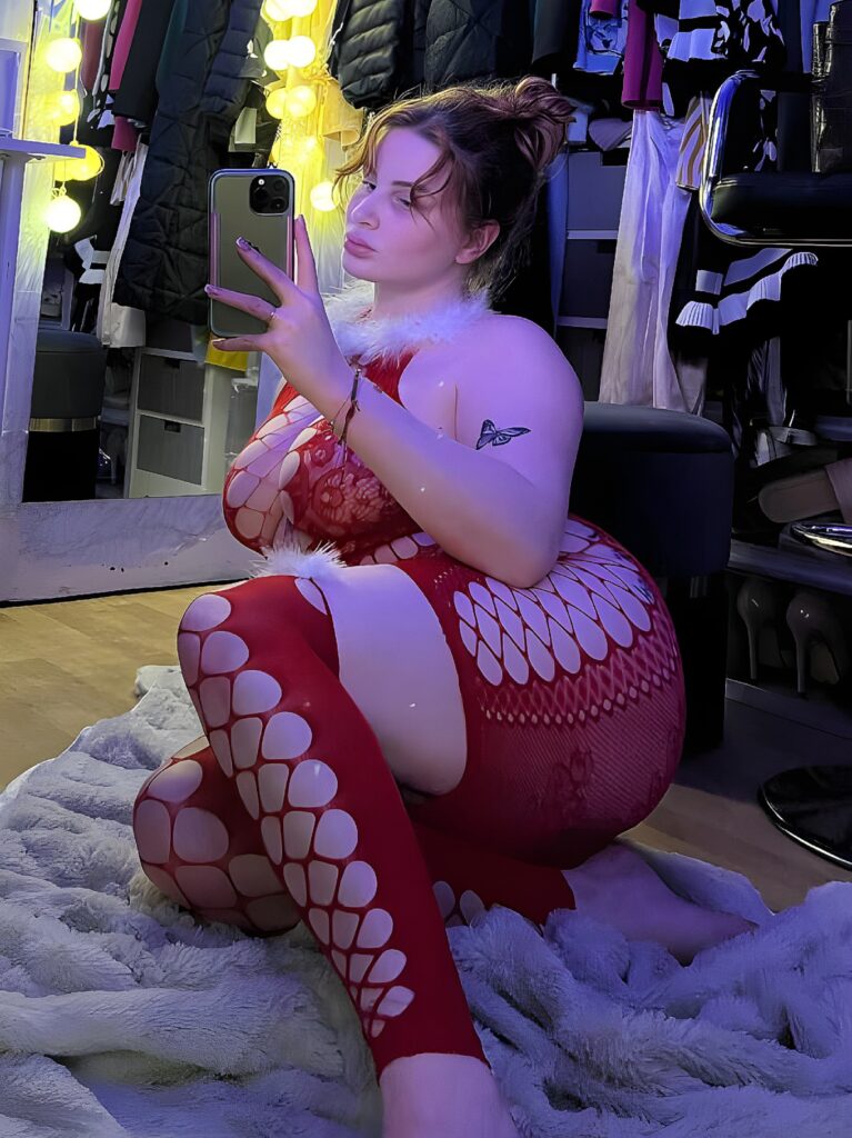 PureHumanSoul posant sensuellement en justaucorps, assise dans une chambre